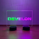 Company branded rectangular LED acrylic sign glowing in multi-color at a corporate conference display