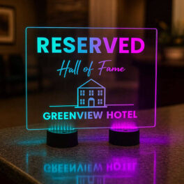 Large acrylic LED table centerpiece sign displaying a reserved hotel message with glowing colors.