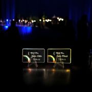 Two glowing light up acrylic table cards at a wedding