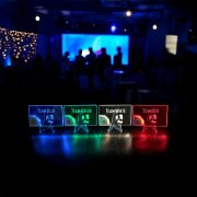Four vibrant acrylic cards displayed on a table, showcasing teams in a color-coded arrangement