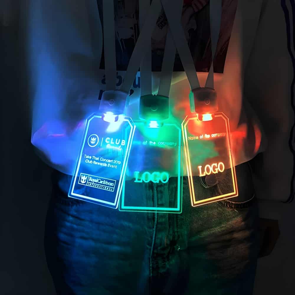 Person-Wearing-Personalized-LED-Badges Close up of person wearing three different LED ID badge designs around their neck, each lighting up a different LED color, blue, green, and orange