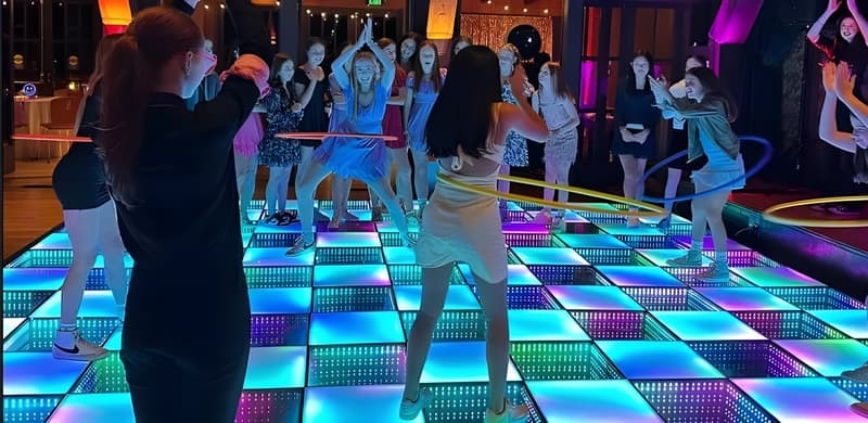 People dancing on a light up dance floor with LED tiles